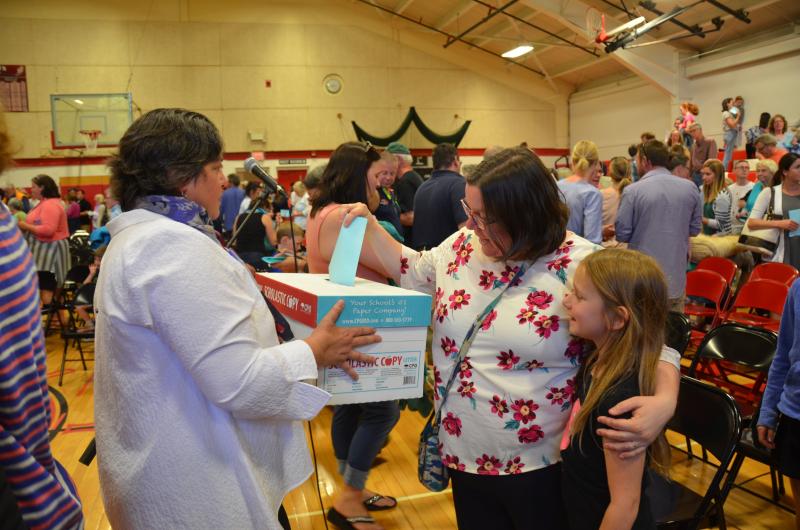 SAD 28 District Superintendent Maria Libby holds a ballot box while a citizen casts her vote. (Photo by Lynda Clancy)