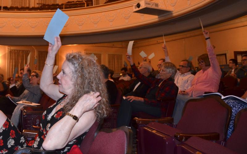Camden citizens raise their hands in opposition to divesting approximately 200 feet of an old Arey Road easement June 13 at the annual 2018 Town Meeting.