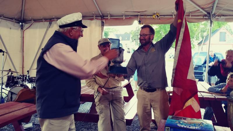 Captain of the Stephen Taber, Noah Barnes, presents Captain of the Schooner Heritage with the Cutty Sark Award trophy and accompanying “Eat My Wake” flag during the Great Schooner Race Awards. (Photo courtesy of Maine Windjammer Association)
