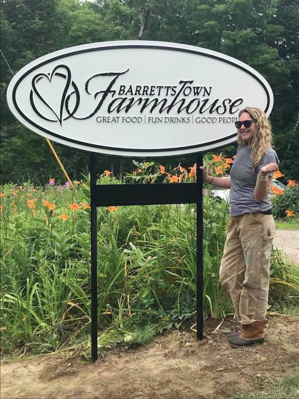 Jessi Wootton stands beside the sign welcoming guests to her restaurant, Barrettstown Farmhouse, located at 42 Hatchet Mountain Road in Hope. Barrettstown Farmhouse will open for business on Wednesday, August 1. (Photo courtesy of Jessi Wootton)