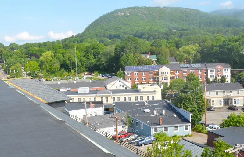A bird’s eye view over the side of the Camden Opera House roof to Mount Battie. The snow and rain streams down the sides of the steep slate roof, and some collects in the gutters, but instead of draining down the spouts, it leaks through the holes in the gutters and then between the walls and the roof, and eventually inside the Opera House itself. (Photo by Lynda Clancy)