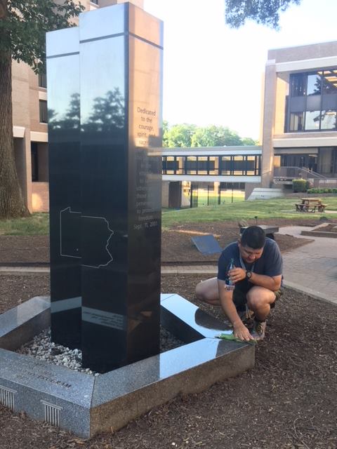 A member of the 273rd session cleans a Sept. 11, 2001, memorial at the FBI’s Quantico Virginia campus. (photo courtesy of Chief Deputy Trundy)