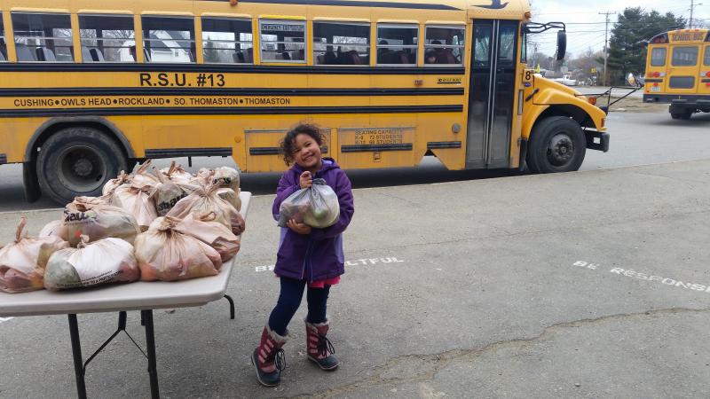 Kindergartener Kamea Thomas helps to hand-out Grab'n'Go produce bags during dismissal at South School in April. (Photo courtesy Brenda Thomas)
