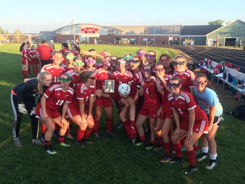 The Camden Hills girls soccer team celebrates Kristina Kelly’s 100th career goal. (Courtesy Steve Alex)