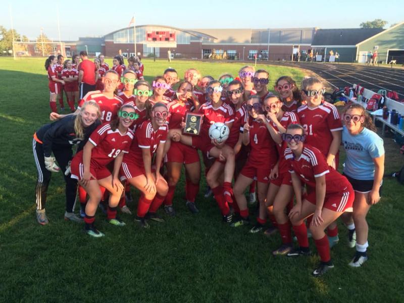 The Camden Hills girls soccer team celebrates Kristina Kelly’s 100th career goal. (Courtesy Steve Alex)