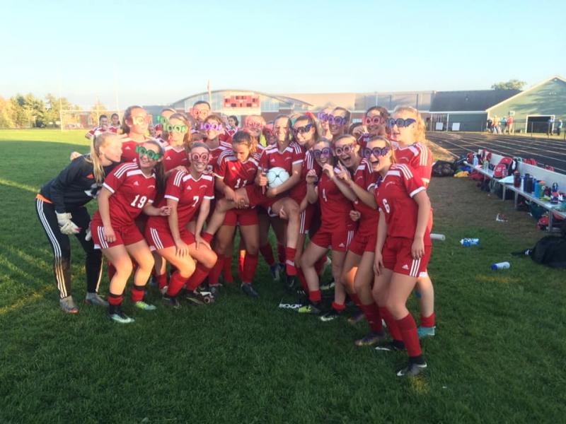 The Camden Hills girls soccer team celebrates Kristina Kelly’s 100th career goal. (Courtesy Steve Alex)