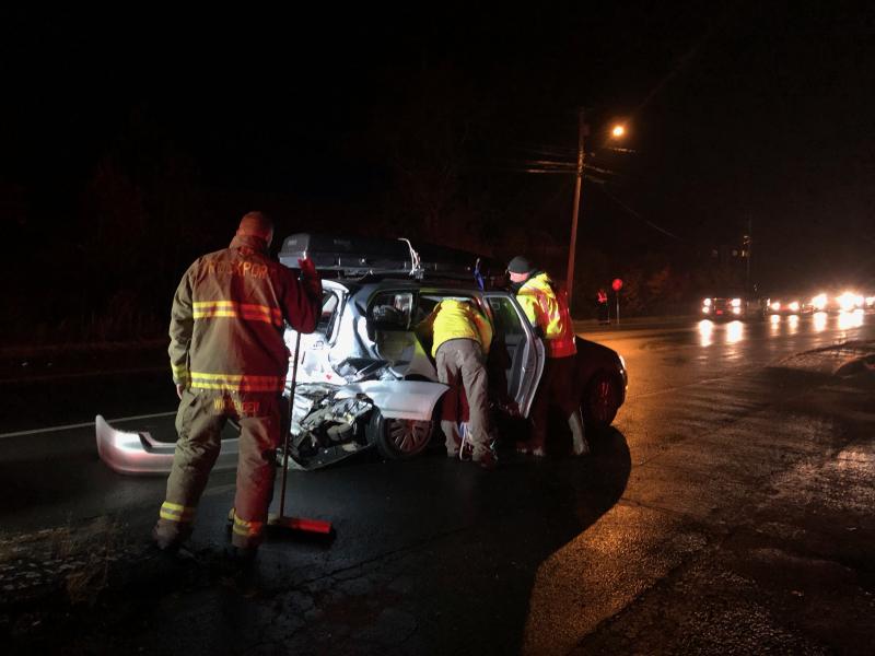 Firefighters and the car owner get the Volkswagen ready for towing. (Photo by Lynda Clancy)