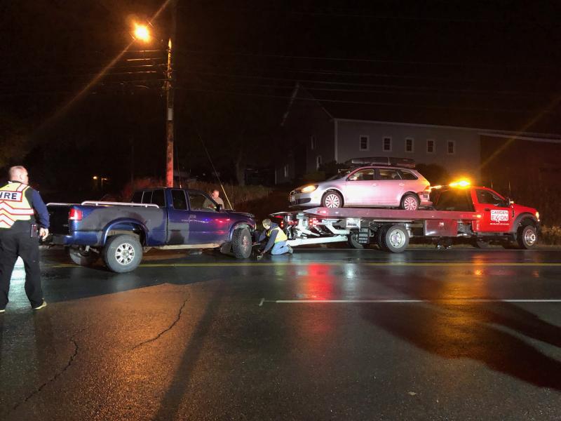 Steve Laite, owner of Camden Exxon, hooks the truck to the trailer and gets ready to haul both vehicles back to the garage on Route 90. (Photo by Lynda Clancy)