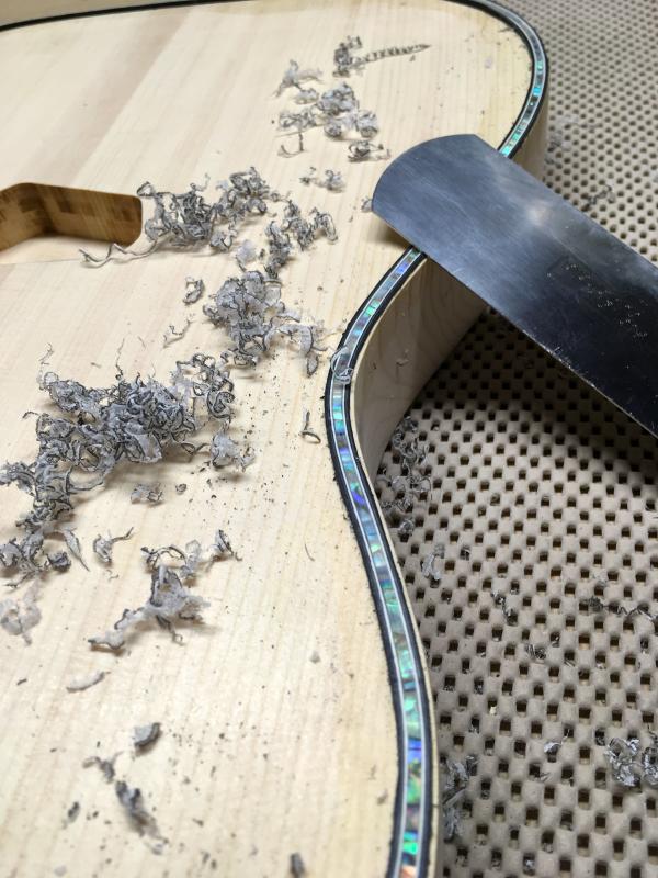 The purfling of a Northwoods guitar is scraped during the guitar making process. (Courtesy Thad Chilton)