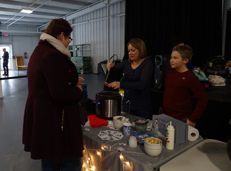 Jill Artkop serves some of her chili to a taste-tester. (photo by Erica Thoms)