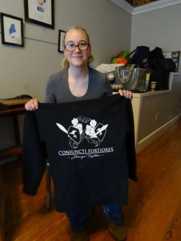 Allison Harrell stands with a Game Loft sweatshirt, designed by the youth board. (photo by Erica Thoms)