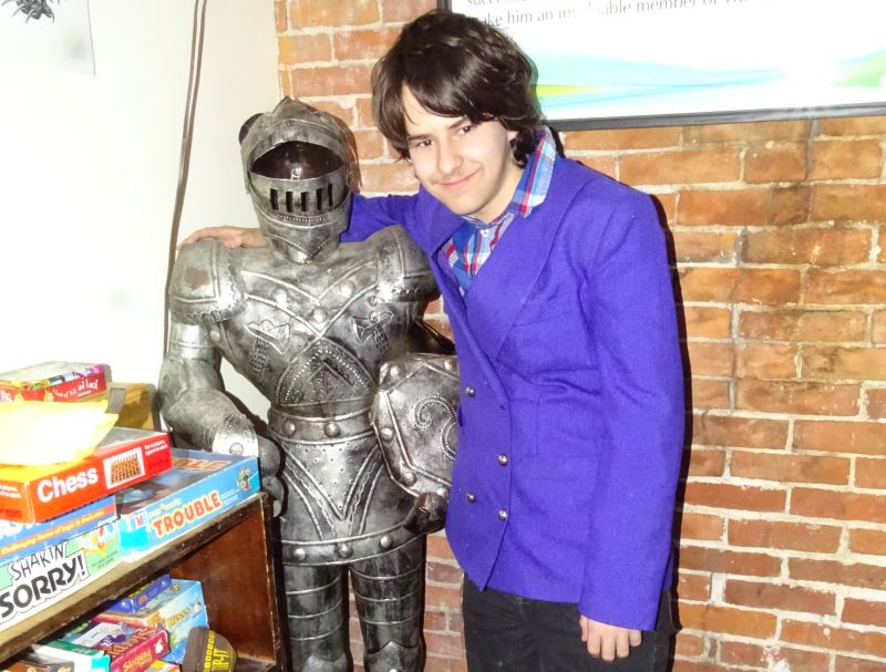 Damian Whitmore poses with an armored statue. (photo by Erica Thoms)
