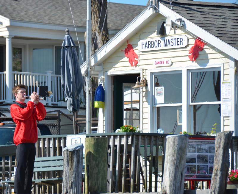 A Camden Hills Regional High School Marching Band player sends taps across the water at the Camden Public Landing. (Photo by Lynda Clancy)