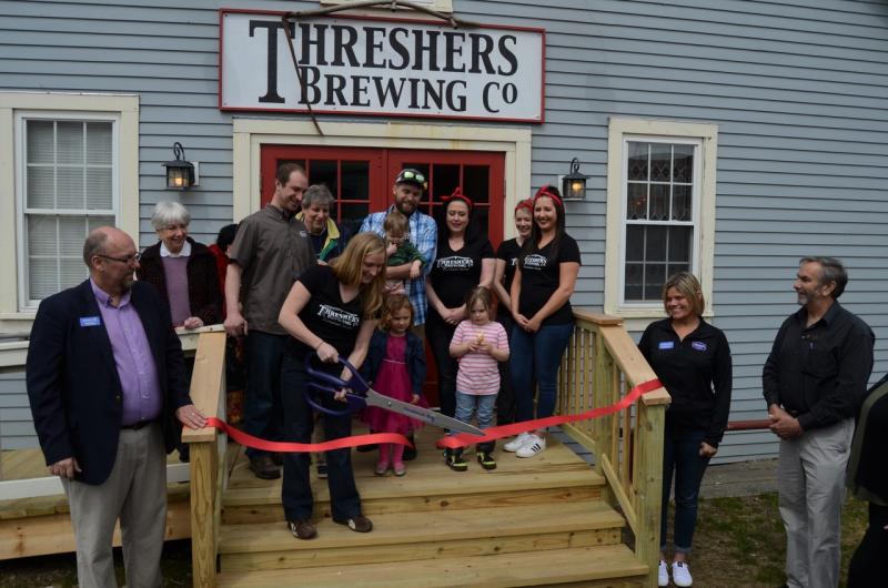 Back row: Davene Fahy, Gina Josephs and Andrew Josephs of Main Street Matters,
Front left: Tom Peaco, of Penbay Chamber of Commerce; Ethan Evangelos, owner; Jen Evangelos, cutting the ribbon; Scott Bendtson, owner; Nicole Bendtson, Ingrid Anderson and Nicole Angelico. Shelby Riley, next to the stairs, chamber of commerce; and Sen. Dave Miramant. (Photo courtesy Threshers)