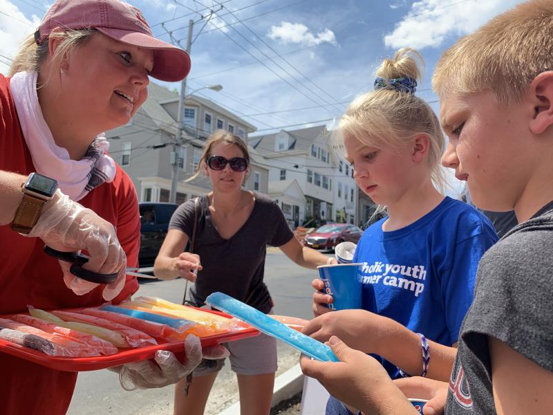 Casey Colby of Wiscasset’s Red’s Eats offers pops to Granville, Ohio siblings Annabelle Bergeron, 10, and A.J. Bergeron, 9, as their family waited in line Saturday afternoon, July 20. SUSAN JOHNS/Wiscasset Newspaper