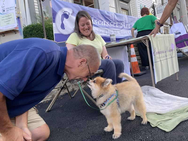 Wiscasset’s David Flynn meets with Tye as the Pomeranian’s owner Lisa Fourre looks on at Wiscasset Art Walk’s Aug. 29 installment. SUSAN JOHNS/Wiscasset Newspaper