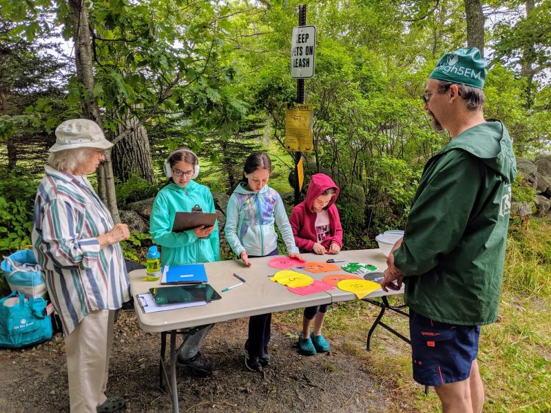 Judith Jones, Iris Eckelman, Petra Jones-McKeon, and Hazel Eckelman check in swimmer Dan Dalrymple. (Photo by Aili Jin)