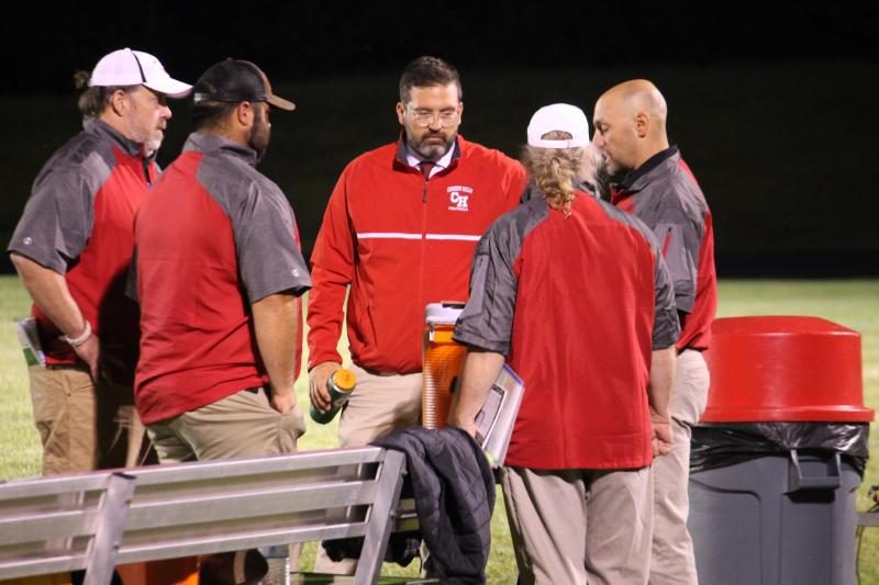 Camden Hills head football coach Jeremy Marks (facing) talks with his assistant coaches at a Sept. 6 game against Old Town. (Courtesy Sally Russillo)