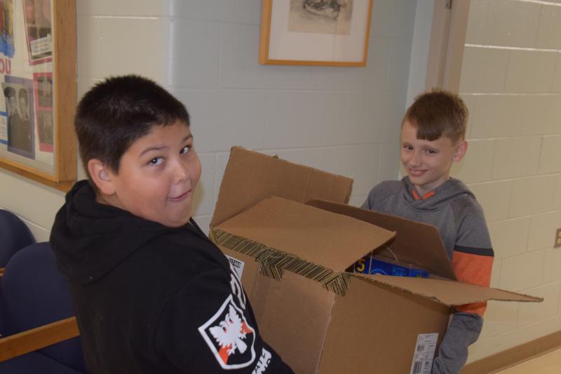 Teamwork! Brody Douglas and Levi Murphy lug a large box of food together. (Photo courtesy Thomaston Grammar School)