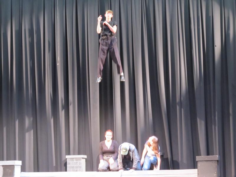 Wesley Henderson, one of the students playing Bert in Mary Poppins, is lifted on the Track on Track flying system while the cast looks on. (Photo by Kay Stephens)