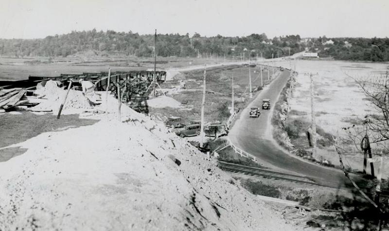 This photograph was taken during construction of the Station 46 bridge in the early 1930s. Vehicles are shown crossing the dike on Atlantic Highway, today known as U.S. Route 1. Courtesy of Woolwich Historical Society