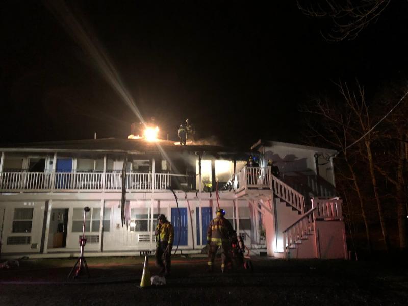 Firefighters drill holes through the roof as they search for hotspots following knockdown of the initial blaze. (Photo by Lynda Clancy)