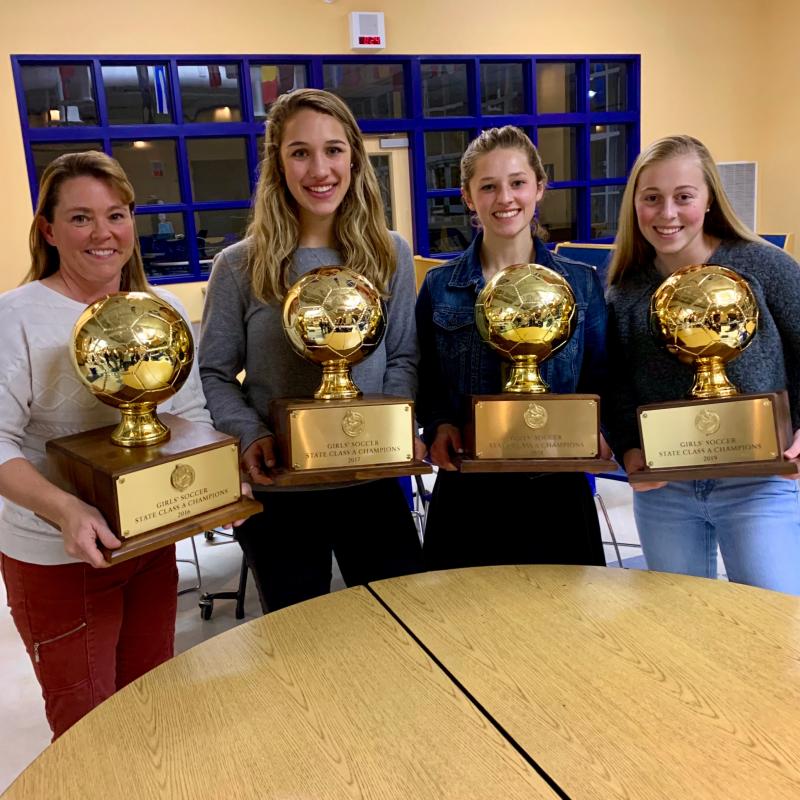 Senior captains with Coach Messer posing with all four gold balls. They all played a part in winning each championship. (Photo courtesy Alison Contento)