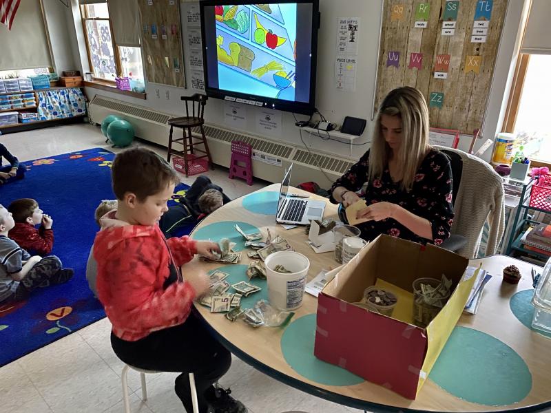 Liam and Ms. Babb count the money from the bake sale. Photo courtesy Alison Babb.