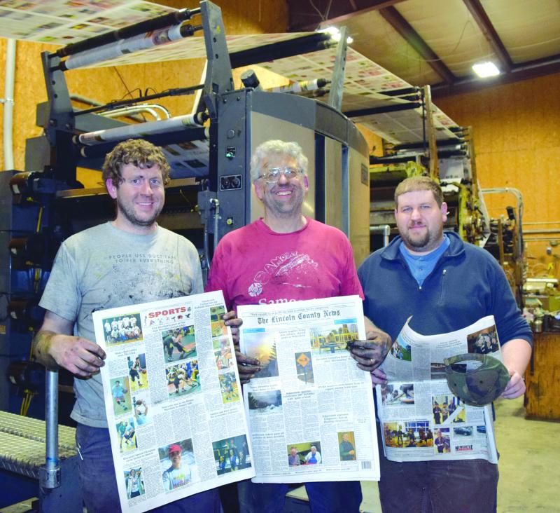 After working all night to complete the installation of two new color units, The Lincoln County News publisher Chris Roberts, center, and associate publishers John Roberts, left, and Allan Roberts hold copies of the March 30, 2017 edition. J.W. Oliver photo