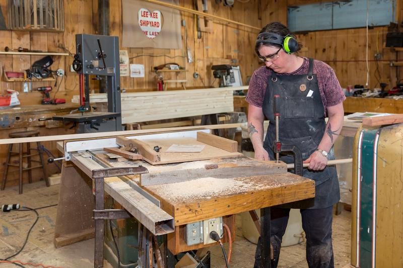 Emma is coving out the rub rails for the Mary Lacy using the table saw. This is one of the final steps in the Susan Skiff build. (Photo by Erin Tokarz)