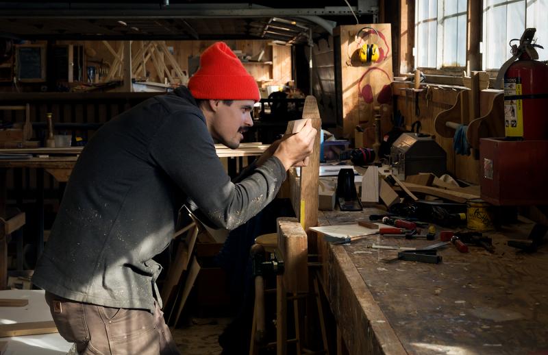 Chris Battaglia, another recent 12-week apprentice, works on the complex joint where the chines of the boat come into the bottom of the stem. The techniques he is learning in the context of this difficult task – problem solving, 3-D visualization, persistence in the face of challenge – are not just specific to boatbuilding. They apply to all different kinds of pursuits. (Photo by Erin Tokarz)