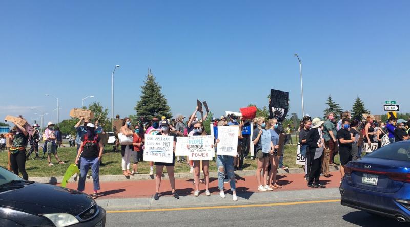 The protest was well attended and spirited, and the signs highly original. (Photo courtesy Molly Mulhern)