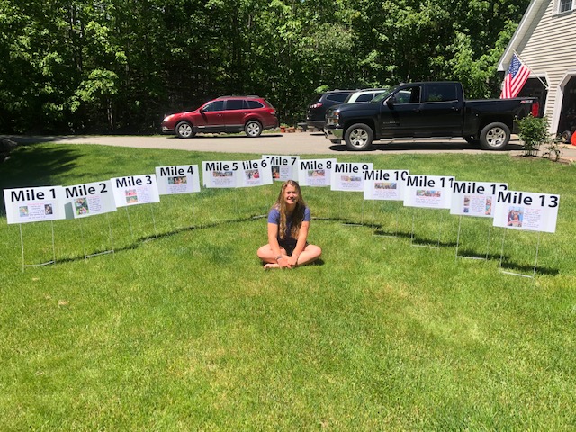Abigail Nathan sitting in front of the special mile markers. (Courtesy Christine Nathan)