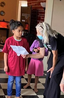 Big Brothers Big Sisters of Mid-Maine Androscoggin Manager Jennifer Cartmell shares a letter with Little Sister Briella Graves that was written by her Big Sister and Bates College mentor, Ellie Boyle. (Photo courtesy Big Brothers Big Sisters of Mid-Maine)