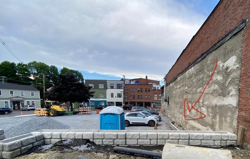 The site of the Year 2020 Camden Time Capsule sits snugly against the wall of a Mechanic Street building. The arrow marks the spot. Don’t forget! (Photo courtesy Alison McKellar)
