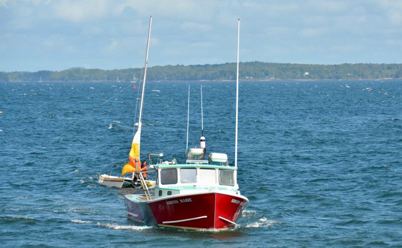 Nick Heal, captain of the Kristin Marie, along with crew members Alex Bryant and Jared Gilbert tow the disabled catamaran and sailor Brendan Browne back to the Lincolnville Harbor dock, beside the ferry landing at Lincolnville Beach. (Photo by Lynda Clancy)