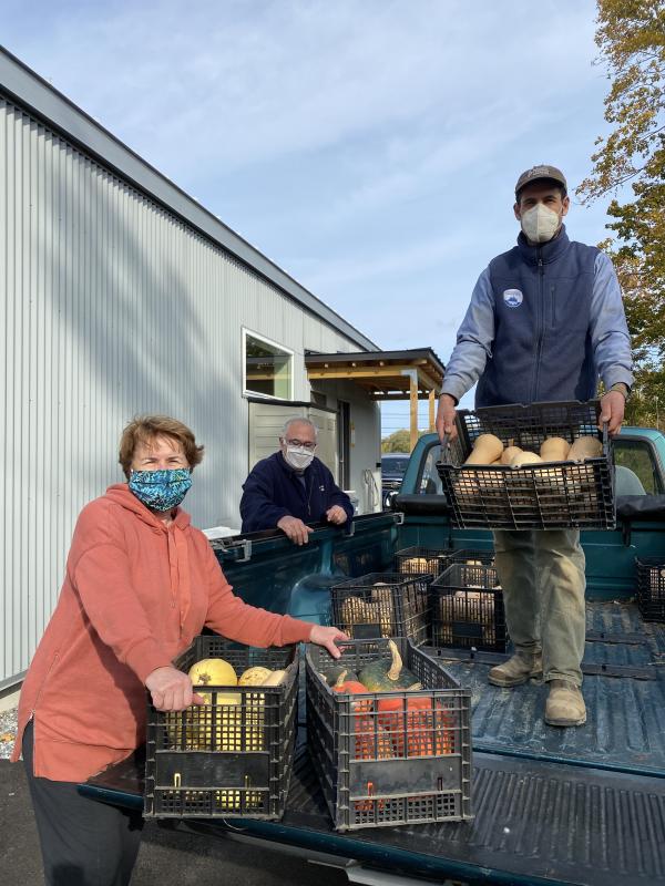 (Left to right) MCHT's MOFGA apprentice, Liv Caron, and MCHT's Erickson Fields Farm Manager, Aaron Englander, stand by the sign at AIO's new building in Rockland. (Photo courtesy Maine Coast Heritage Trust)