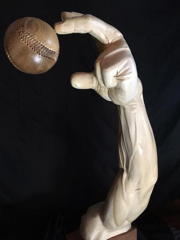 A wooden sculptured pitcher’s arm, created by Rockport Jon Moro, releases a baseball. (Courtesy Jon Moro)