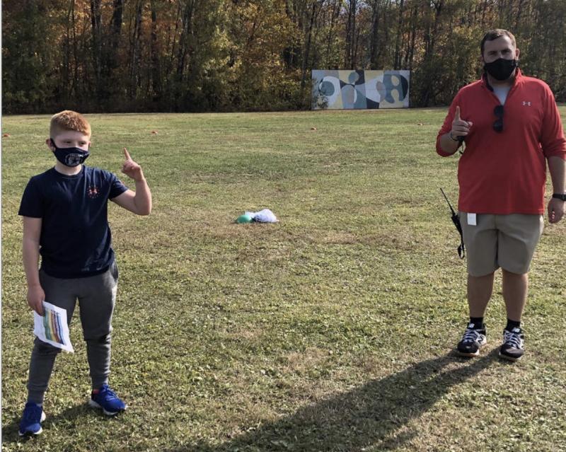 Budding reporter Brody Ingraham, left, a fourth grader at Capt. Albert W. Stevens School, talks with gym teacher Bradley Deuring about how the coronavirus has affected his teaching. (Photo courtesy Nancy Nickerson)