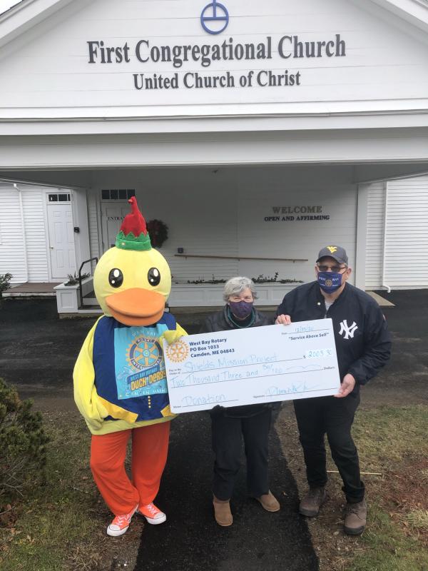 Lucky the Duck and West Bay Rotarian Ray Fink present a check to Shields Mission Project’s administrator Jeanne Denny. (Photo courtesy West Bay Rotary)