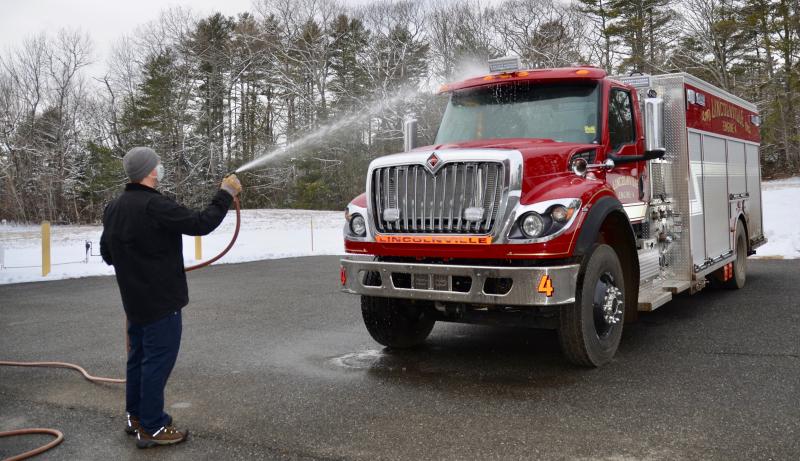 Lincolnville Fire Chief Don Fullington III cleans highway dirt off the town’s newest addition to its fleet of fire engines Jan. 28. Built in New York, and finish details applied in Brunswick, Engine 4 arrived just after 2 p.m. (Photos by Lynda Clancy)