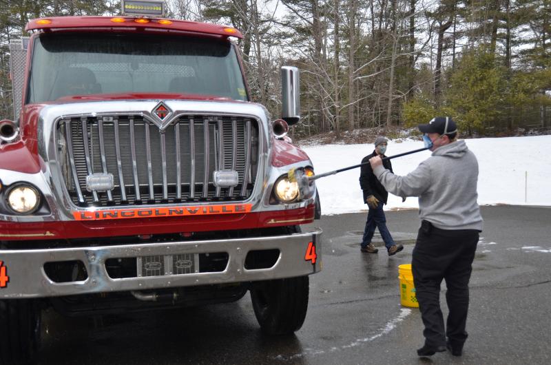 Lincolnville firefighter Cameron Freeman gets to work scrubbing down Engine 4.