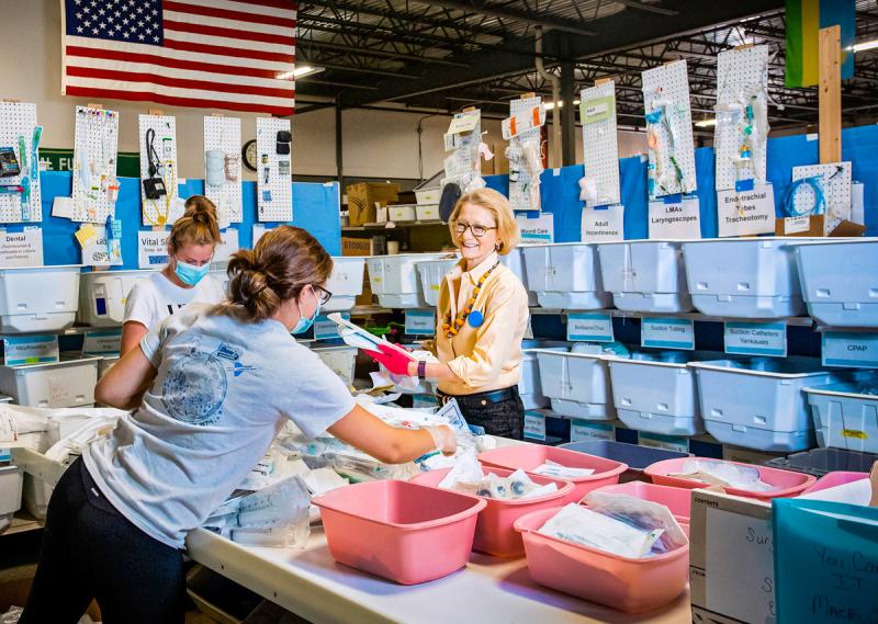 Partners for World Health founder Elizabeth McLellan, facing, sorts medical supplies with a pair of volunteers in the organization’s Portland warehouse. (Courtesy Partners for World Health)