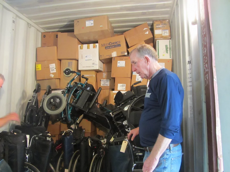 A Partners for World Health volunteer stands among a container packed with donated medical supplies to be shipped to a developing nation, including wheelchairs. (Courtesy Partners for World Health)