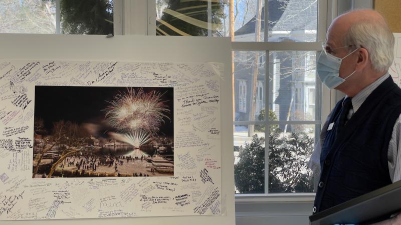 Terri and Peter Ralston presented Culpovich with one of Peter’s beautiful photographs depicting winter fireworks over Rockport Harbor. The margins around the image sardined with hundreds of signatures from town residents and beyond. (Photo courtesy Todd Field)