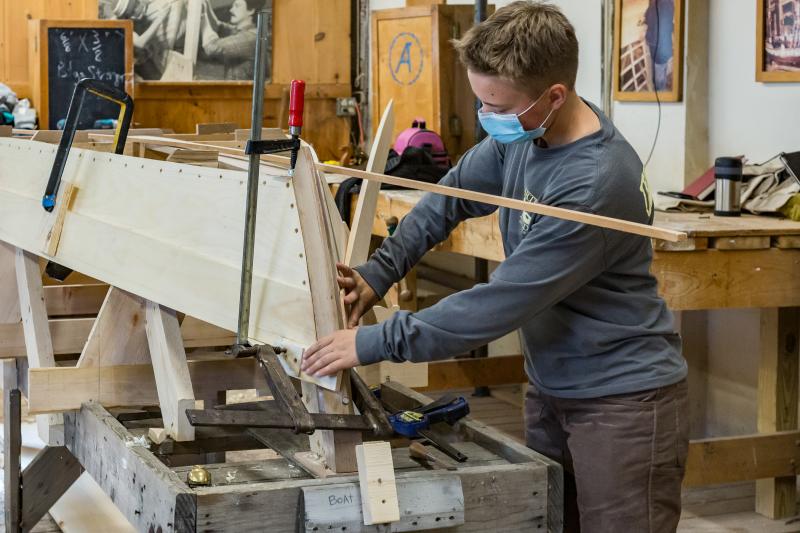 Tabitha fitting the board strakes on her Susan skiff in progress.(Photo by Erin Tokarz)