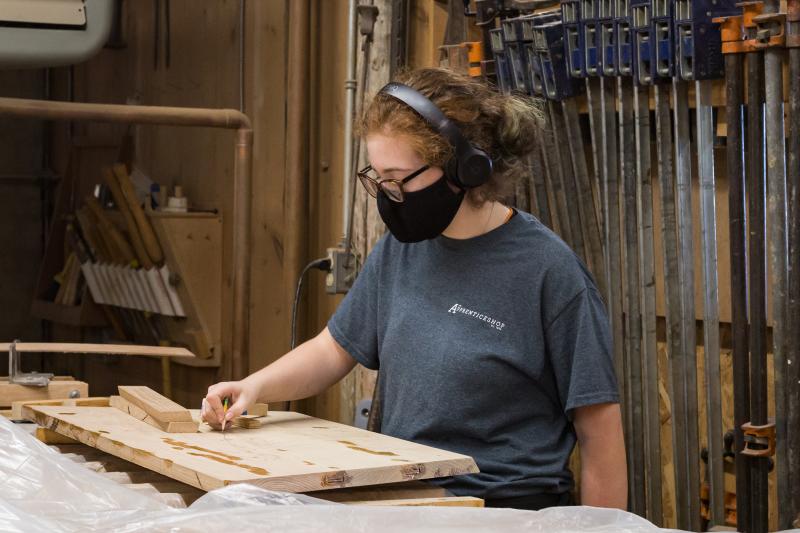 Chloe working on planing down the oak boards she glued up for her transom. Photo credit: Erin Tokarz.