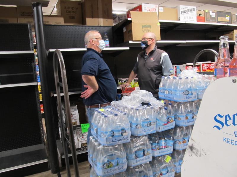 Rob Newcomb and a store associate stock the shelves on the re-opening day. Photo by Kay Stephens