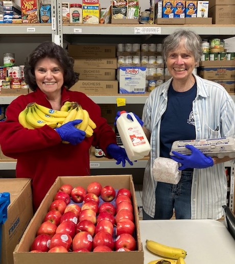 Camden Area Christian Food Pantry volunteers Lorraine Coakley (L) and Pauline Johnstone (R) show the array of items available at the food pantry.