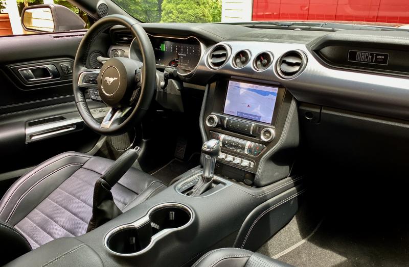 The Mach 1 cabin is all business, but dreary. Note the oil pressure and vacuum gauges above the screen and the bad-boy handbrake lever. Ford calls this Ebony Leather Trim with Orange Accents.